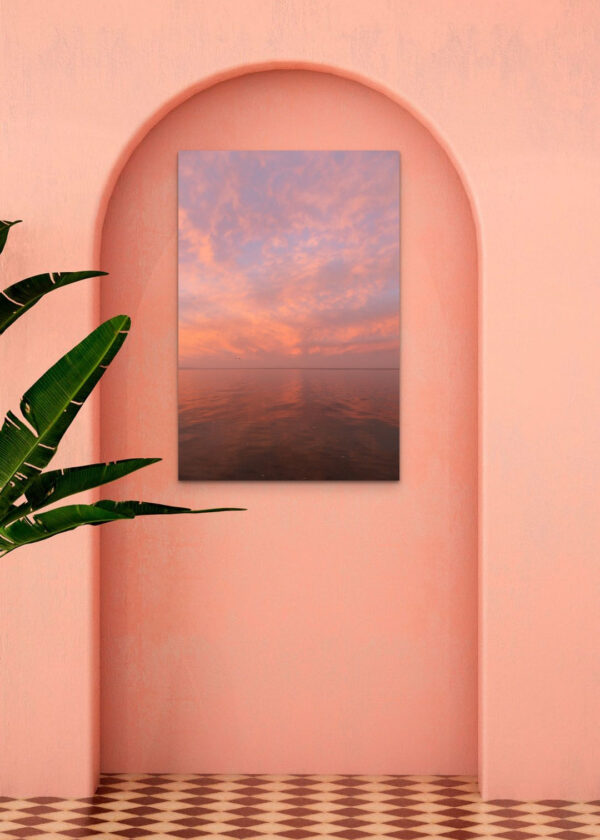 Art with a pink sunset over the sea on a pink wall.